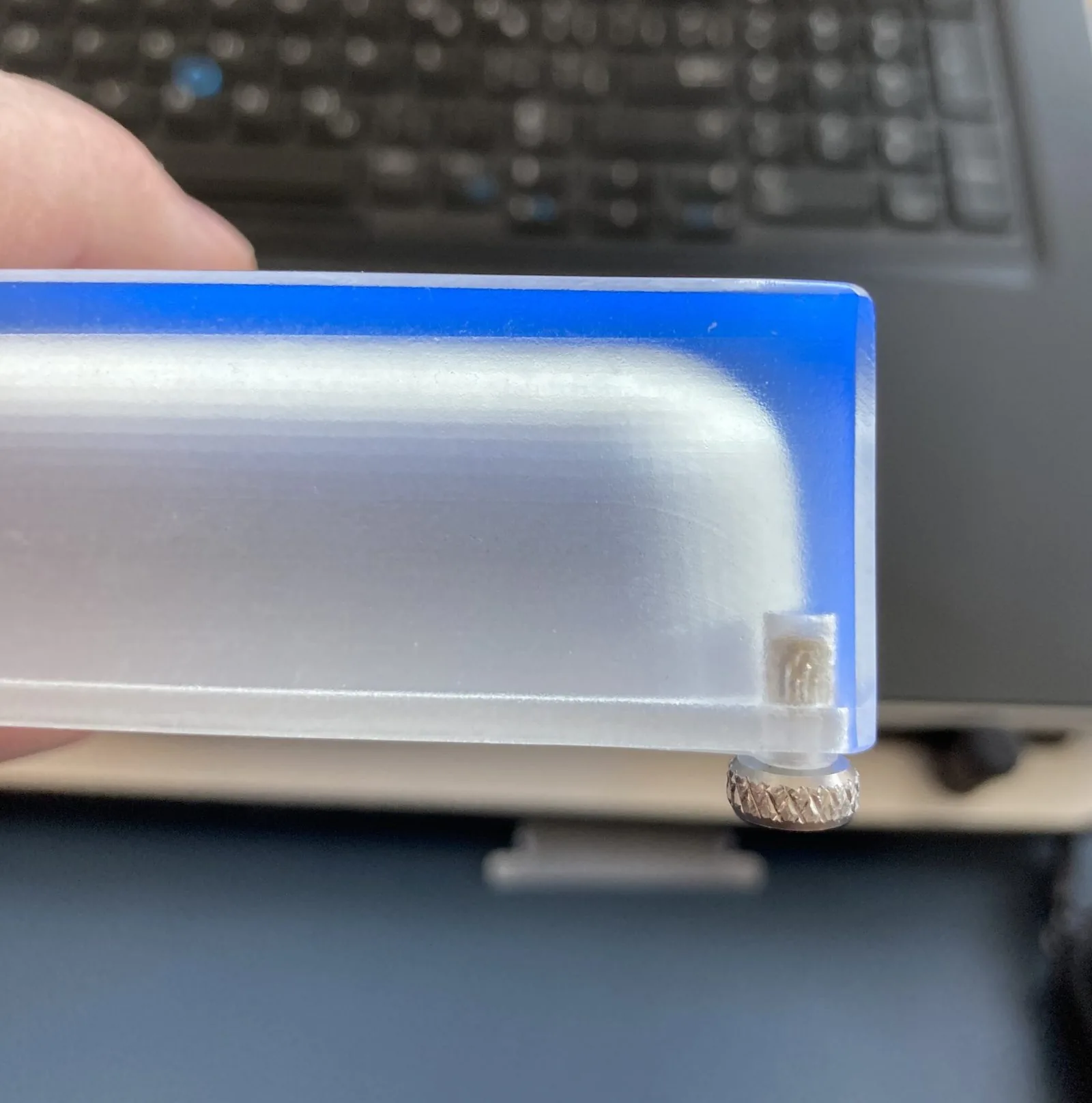 Close-up of a clear prototype's edge and brass foot