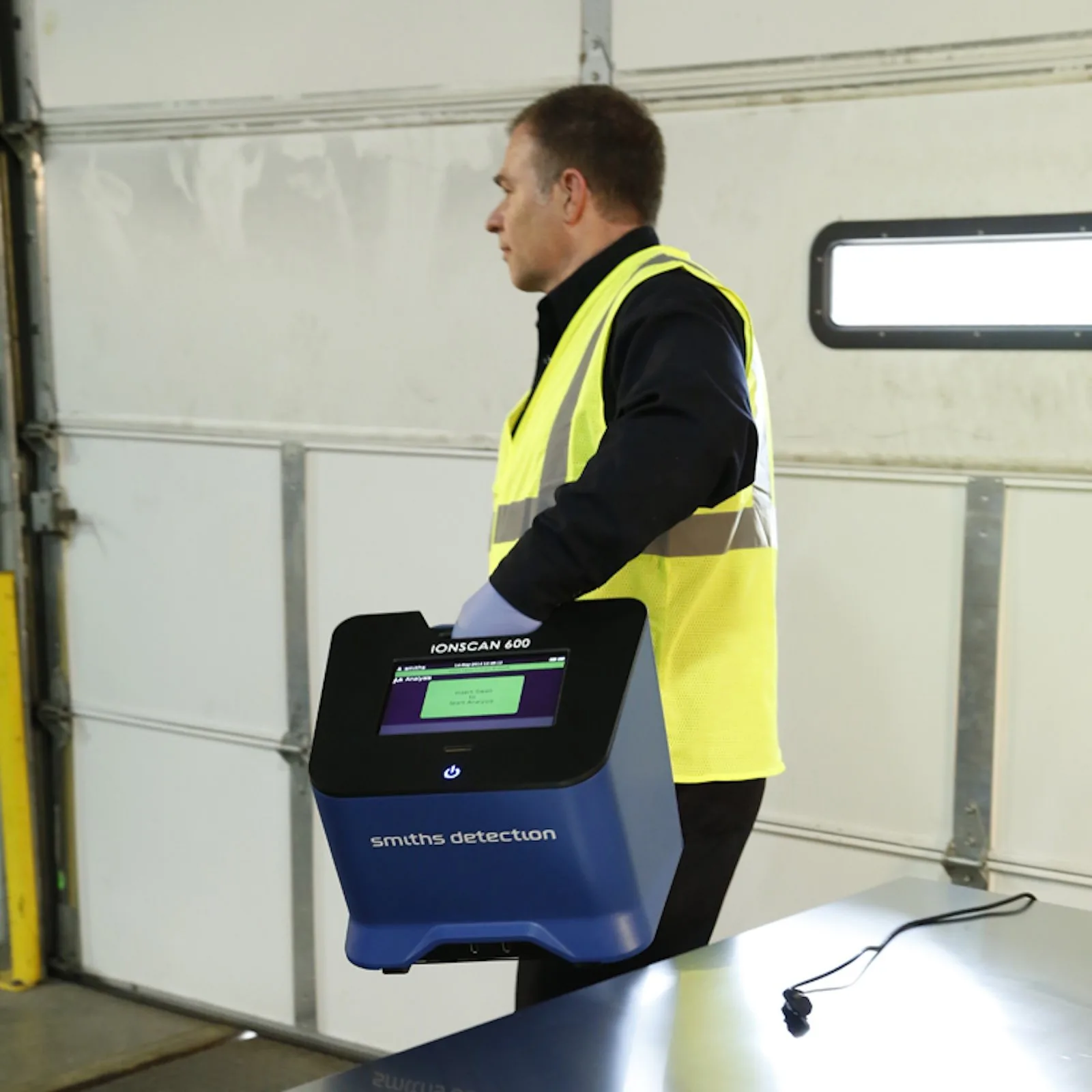 Technician carrying an IONSCAN 600 one-handed by its handle
