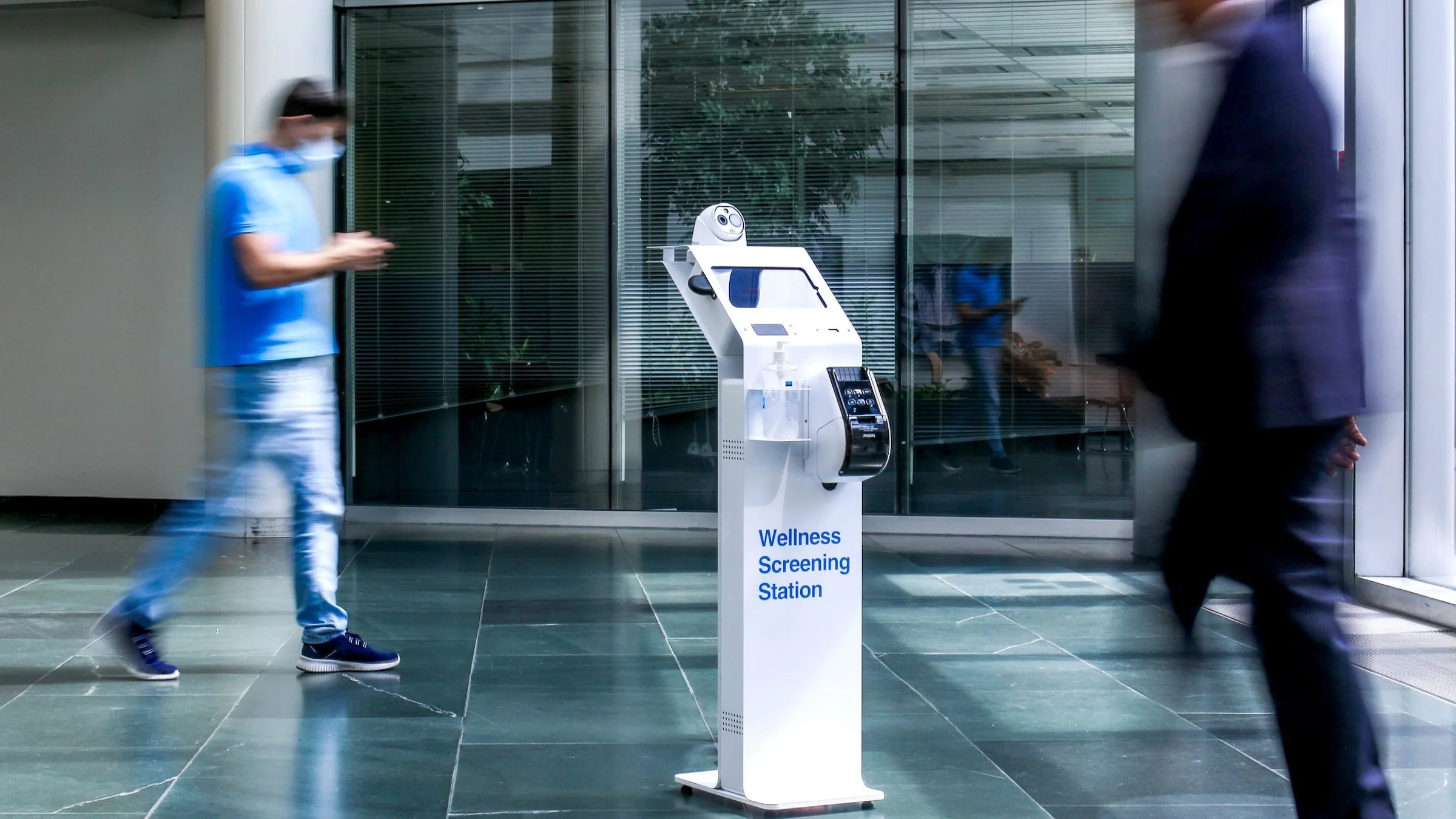 Wellness Screening Station in a building lobby as people walk past