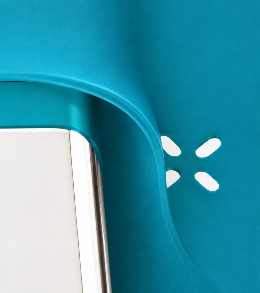 Close-up of a teal Sink Caddy's drainage holes where it drapes over the sink edge