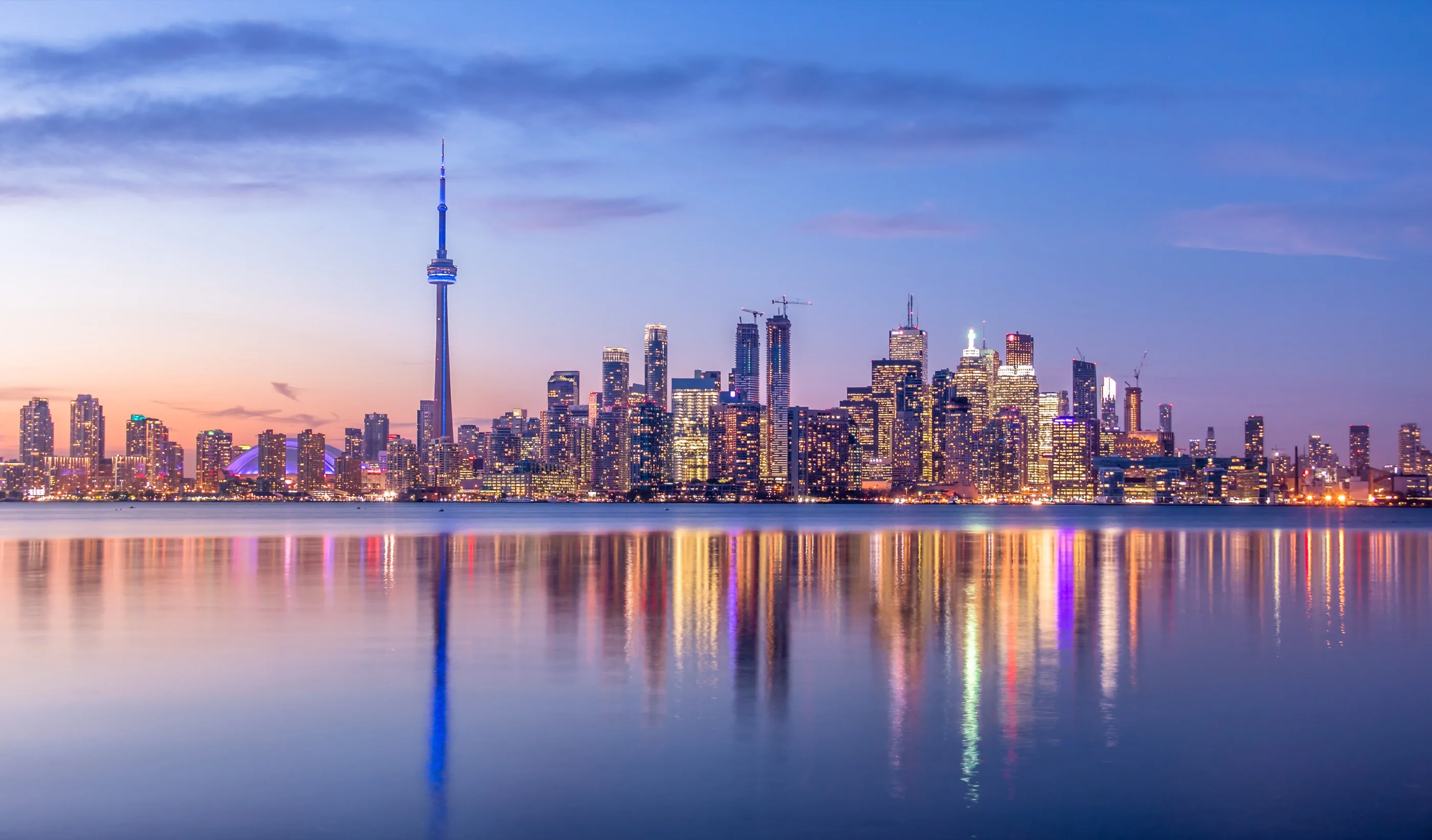 Toronto skyline at dusk, reflected in the lake