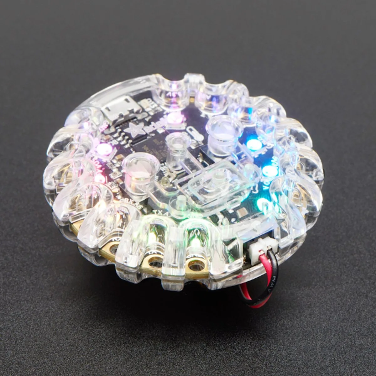 Circuit Playground in its clear enclosure with its LEDs lit
